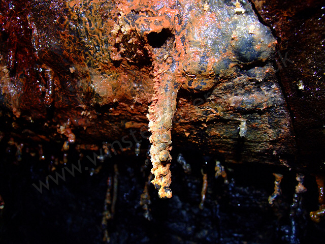 A lava tube formation, encrusted in mineral deposits.